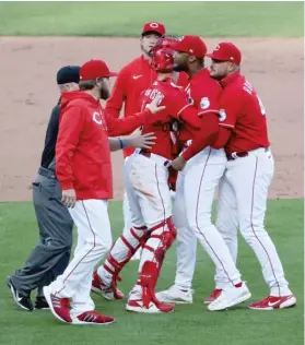  ?? GETTY IMAGES PHOTOS ?? At left, the Reds’ Mike Moustakas gets in the way of the Cubs’ Javy Baez during a bench-clearing incident Saturday. At right, the Reds’ Amir Garrett is restrained by teammates during the incident.