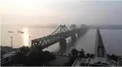  ??  ?? This file picture taken on September 4, 2017 shows the North Korean town of Sinuiju (at rear) being seen behind the Friendship Bridge (L) which connects Sinuiju and the Chinese border city of Dandong, and the Broken Bridge, in Dandong, in China’s...