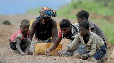  ?? AP ?? Residents of Mozambique look for stones they can sell as building materials. A New Zealander has been arrested in a loans scandal that nearly bankrupted the country, already one of the poorest nations in the world.