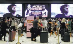  ?? SAM MORRIS/ LAS VEGAS REVIEW-JOURNAL ?? People wait Friday to check in at MGM Grand under a sign advertisin­g the upcoming fight between Floyd Mayweather Jr. and Manny Pacquiao.