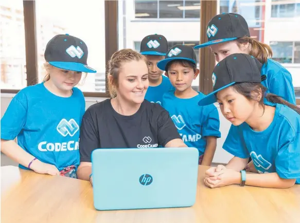  ??  ?? Students surround a Coding Camp teacher at last year’s Camp Code, while learning how to use pure java script.