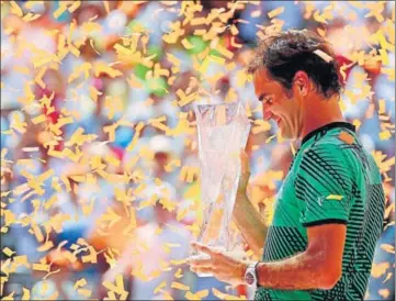  ?? AFP ?? Roger Federer holds the Miami Open trophy as confetti is showered on him after his triumph over Rafael Nadal on Sunday.