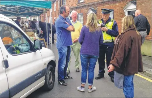  ??  ?? Villagers react after trader Frankie Botterell received a parking ticket at the Wye Farmers Market.