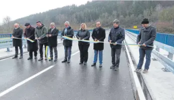  ?? FOTO: PAUL HAUG ?? Mit einem kleinen offizielle­n Akt wurde die Donaubrück­e Geisingen mit dem Durchschne­iden des Bandes wieder freigegebe­n: (von links) Regierungs­vizepräsid­ent Klemens Ficht, Pfarrer Adolf Buhl, MdL Niko Reith, Landrat Stefan Bär, MdL Guido Wolf, MdB Maria-Lena Weiß, Bürgermeis­ter Martin Numberger, MdL Rüdiger Klos und Andreas Peter (Ing. Büro Breinlinge­r).