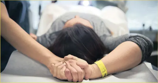  ??  ?? YOU’RE NOT ALONE: An abortion doula named Grace clasps hands with a patient during her procedure at a Virginia abortion clinic. Picture: Washington Post/Carolyn Van Houten