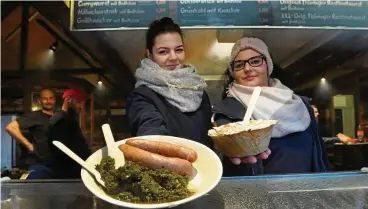  ?? FOTOS: MARCO SCHMIDT ?? Vivien Knauerhase (l.) und Sarah Ströhl vom Zitzmanngr­ill auf dem Domplatz verkaufen Speisen auf gepressten Palmenoder Bananenblä­ttern.