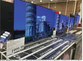  ?? (AP/David Zalubowski) ?? A sign displays the price of a 65-inch television­s lined up in a Costco warehouse in Lone Tree, Colo. The Commerce Department reported Thursday that the economy grew at a 6.6% annual rate last quarter.