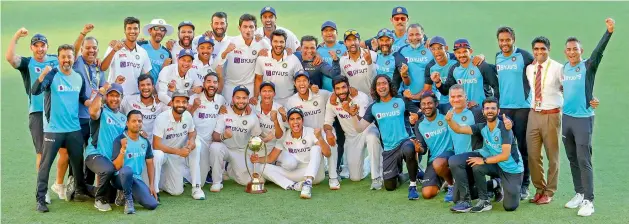  ?? — AP ?? Indian players celebrate with the trophy after defeating Australia by three wickets on the final day of the fourth Test at the Gabba in Brisbane on Tuesday. India won the four-Test series 2-1.