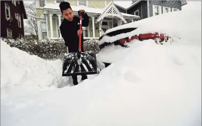  ?? Erik Trautmann / Hearst Connecticu­t Media ?? Nery Lopez digs out around his vehicle at his residence on Elizabeth Street following the snowstorm Thursday in Norwalk.