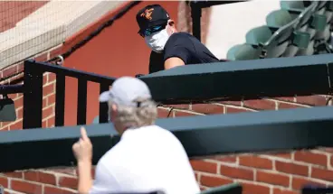  ?? ROB CARR / GETTY ?? Baltimore manager Brandon Hyde (background) talks with general manager Mike Elias as they watch the team during their first summer workout at Oriole Park at Camden Yards in Baltimore on July 3.