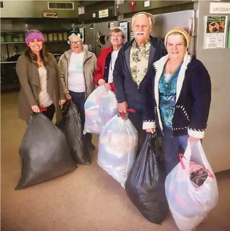  ??  ?? Jo Boone (far right) and crafters Quilla Mayo, Camilla Isenhour and Cecil Riley deliver hats to local soup kitchen manager Summer Jenkins (left).