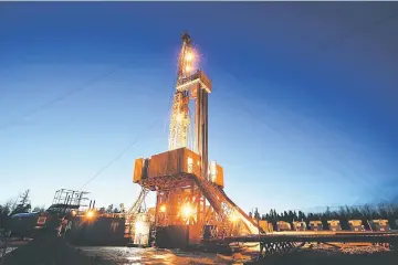  ?? — WP-Bloomberg photo ?? An oil drilling rig stands illuminate­d at night in an oilfield in Russia.