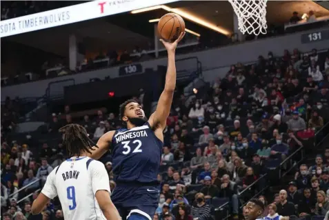  ?? (AP) ?? UP AND SHOOT. Minnesota Timberwolv­es center Karl-Anthony Towns goes up to shoot past Dallas Mavericks center Moses Brown during the first half of an NBA basketball game Sunday, Dec. 19, 2021, in Minneapoli­s.