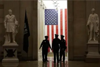  ?? Susan Walsh/Associated Press ?? Capitol Police officers talk Monday in the Capitol Rotunda on Capitol Hill in Washington. The department is asking members of Congress to be vigilant while traveling.