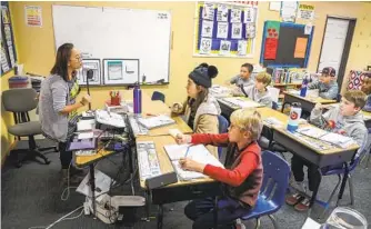  ?? EDUARDO CONTRERAS U-T ?? Teacher Sokry Koeut works with fourth- and fifth-grade students on a phonics lesson at the New Bridge School in Poway. New Bridge caters to students with dyslexia.