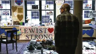  ?? ASSOCIATED PRESS 2023 ?? Volunteer Rich Beard looks over archived items, many left at memorials outside the Oct. 25 mass shooting sites in Lewiston, at the Maine Museum of Innovation, Learning and Labor in Lewiston, Maine. The businesses where 18 people were killed are reopening.