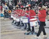  ??  ?? A group of young drummers play for a large crowd of children and parents who braved chilly temperatur­es to watch the annual holiday parade.