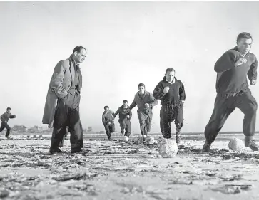  ??  ?? Dundee United players get down to training at Carnoustie beach in 1951, watched by manager Jerry Kerr.