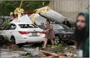  ?? GERALD HERBERT — THE ASSOCIATED PRESS ?? Robin Marquez walks past her son's heavily damaged car after they sheltered in place for what she said was a tornado, in the aftermath of severe storms that swept through the region in Slidell, La., on Wednesday.