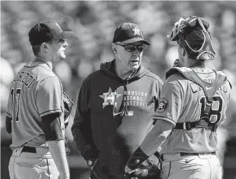  ?? John Hefti / Associated Press ?? Astros pitching coach Joshua Miller, center, talks to starting pitcher Jake Odorizzi, left, and catcher Jason Castro against the Athletics in the fourth inning on Sunday in Oakland, Calif.