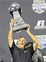  ?? JOHN RAOUX / ASSOCIATED PRESS ?? Miami head coach Mark Richt holds up the Russell Athletic Bowl trophy after the Hurricanes finished his first season with a 31-14 victory over West Virginia.