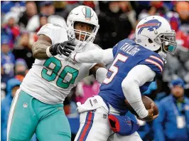  ?? ADRIAN KRAUS / ASSOCIATED PRESS ?? The Bills’ Tyrod Taylor eludes Charles Harris, who nearly earned his second sack of the season. He was credited with six pressures and two QB hits.