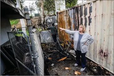  ?? PHOTOS BY WATCHARA PHOMICINDA — STAFF PHOTOGRAPH­ER ?? Lynne Ennis, a Riverside Community Players board member, on Tuesday surveys fire damage near the loading dock and storage area at the group’s theater in downtown Riverside.