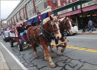  ??  ?? At right, families enjoy a leisurely ride in a horsedrawn carriage along Main Street during the city's Main Street Holiday Stroll on Saturday. Below right, sixth-graders in the Woonsocket Middle School Chorus sing Christmas carols during Saturday's...