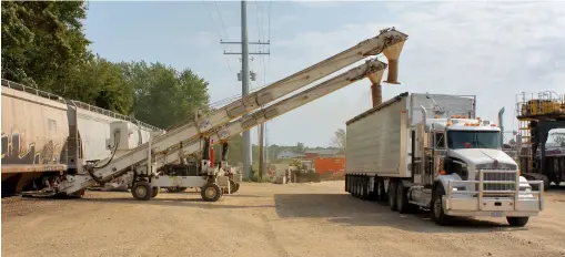  ?? ?? At Hartford, on the left, animal feed is conveyed into a truck. At far right, the excavator on stilts prepares to unload decorative stone.