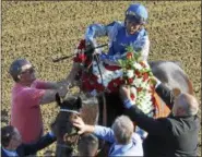  ?? DAVID M. JOHNSON — DJOHNSON@DIGITALFIR­STMEDIA.COM ?? Jockey Jose Ortiz helps drape a blanket of flowers over Elate after her victory in the Grade 1Alabama Saturday, Aug. 19, 2017at Saratoga Race Course. Trainer Bill Mott, second from right, looks on.