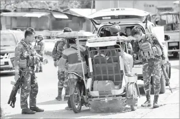  ?? — Reuters photo ?? Philippine National Police Special Action Force personnel man a checkpoint in Marawi city, as government troops continue their assault against insurgents.