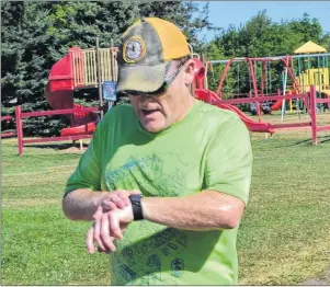  ?? ERIC MCCARTHY/JOURNAL PIONEER ?? David Gamble checks his watch as he crosses the finish line first in the Prince County Exhibition’s 10K Run on Saturday. He ran in a time of 43 minutes 45 seconds (43:45). The Western Region Sport and Recreation Council helped run the event.