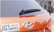  ?? MARTHA IRVINE/ASSOCIATED PRESS ?? A car with a “Let’s Pray For America” bumper sticker is parked at a mall in Bloomingda­le, Ill., that’s housing a polling place for early voters. Americans are headed to the polls for the midterm election.