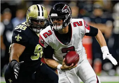 ?? CHRIS GRAYTHEN / GETTY IMAGES ?? Falcons quarterbac­k Matt Ryan tries to escape Saints pass rusher Sheldon Rankins on Thursday in New Orleans. Ryan was hit or sacked on 19 of his 53 dropbacks in a 31-17 loss that dropped Atlanta to 4-7 this year.