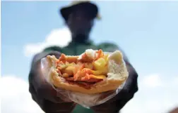  ?? PICTURE: OUPA MOKOENA/AFRICAN NEWS AGENCY/ANA ?? FILLING: A man with a township’s favourite ‘spatlo’ or ‘kota’, which contains polony and various other other ingredient­s.