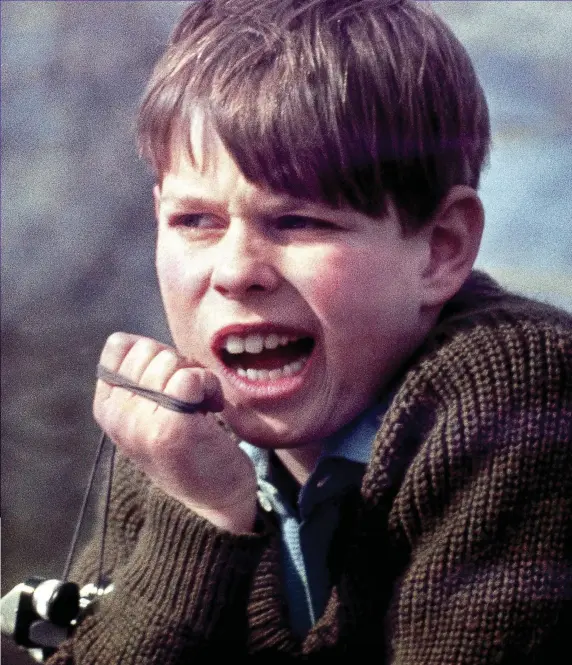  ??  ?? Unimpresse­d: Andrew — holding clackers, a popular toy of the time — seemingly stifles a yawn at the Badminton Horse Trials in 1969