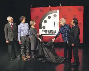  ?? Patrick Semansky Associated Press ?? EXPERTS WITH the Bulletin of the Atomic Scientists unveil the Doomsday Clock, which they moved forward to 90 seconds until midnight on Jan. 24. The clock was establishe­d in 1947.