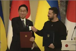  ?? EFREM LUKATSKY — THE ASSOCIATED PRESS ?? Japanese Prime Minister Fumio Kishida and Ukrainian President Volodymyr Zelenskyy, right, greet each other after the signing of joint documents in Kyiv, Ukraine, on Tuesday.