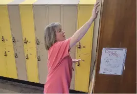  ?? (Pine Bluff Commercial/I.C. Murrell) ?? Watson Chapel High School secretary Jamie Milliken anoints a classroom with oil and says a soft prayer Sunday afternoon, Aug. 13, 2023.