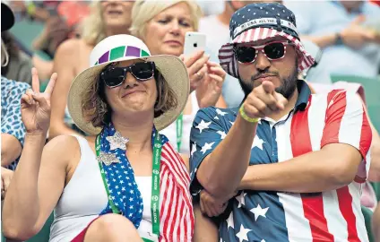  ??  ?? National attire: American fans in stars and stripes enjoy watching their compatriot­s in action yesterday