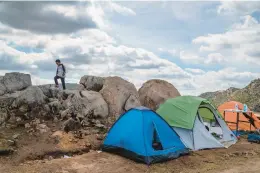  ?? ARIANA DREHSLER/THE NEW YORK TIMES ?? A migrant waits at a campsite March 13 in Campo, Calif. The federal government must quickly house kids from such sites, a judge ruled Wednesday.