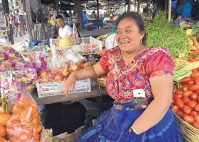  ?? ANGELA KOCHERGA/JOURNAL ?? Dina Muzuzt sells produce at the market in San Martin Jilotepequ­e. She said smugglers are telling parents it’s easier to get into the U.S. with a child.