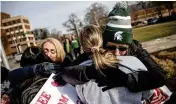  ?? JAKE MAY / THE FLINT JOURNAL ?? Sue Dodde (right) embraces a student with a “free hug from a mom” on Monday at Michigan State University.