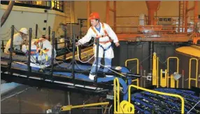  ?? LIANG FUYING / FOR CHINA DAILY ?? Workers check facilities at a project of China General Nuclear Power Corp in Fangchengg­ang, the Guangxi Zhuang autonomous region.