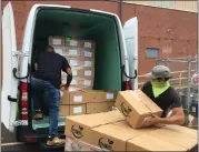  ?? MEDIANEWS GROUP FILE ?? MontCo Anti-Hunger Network Food Resource Driver, Ron Levine, left, and Lansdale Warehouse Company Maintenanc­e Assistant, Steve Wheeler, right, load USDA produce boxes for delivery to area food pantries into MAHN’s van.