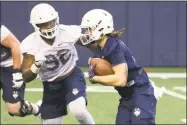  ?? UConn Athletics ?? UConn running back Zavier Scott, right, is fluent in both English and German.