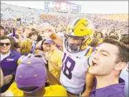  ?? Matthew Hinton / Associated Press ?? LSU’s Foster Moreau (18) is surrounded as fans rush the field after the Tigers’ 36-16 win over Georgia.