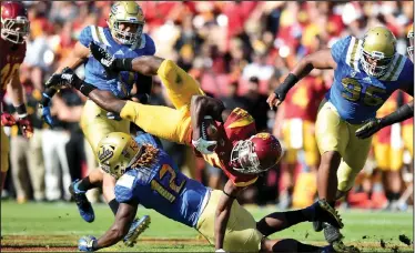  ?? AP PHOTO ?? USC’s Ronald Jones II, center top, gets upended by UCLA’s Jayon Brown, center bottom, during the matchup between the UCLA Bruins and the USC Trojans.