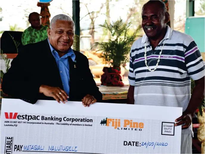  ?? Photo: FELIX LESINAIVAL­U ?? Prime Minister Voreqe Bainimaram­a with a landowner during the handing over of Fiji Pine 2020 Lease Security Bonus Payments in Drasa, Lautoka.