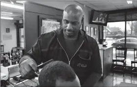  ?? AP/CARLOS OSORIO ?? Barber Thomas Carter cuts a customer’s hair in Detroit on Thursday. Carter says there’s nothing funny about blackface, calling it a “huge form of disrespect” to African-Americans. Past uses of blackface as attempts to humor have clouded the political futures of two of Virginia’s top leaders, while angering many African-Americans who see it as part of America’s painful history of racism, hate and exploitati­on.